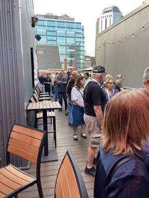 This is a group of people standing in line for a live demonstration performed by a professional mixologist