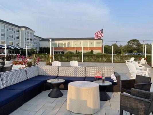 Patio sofa seating area and fire pit overlooking the water and sunset