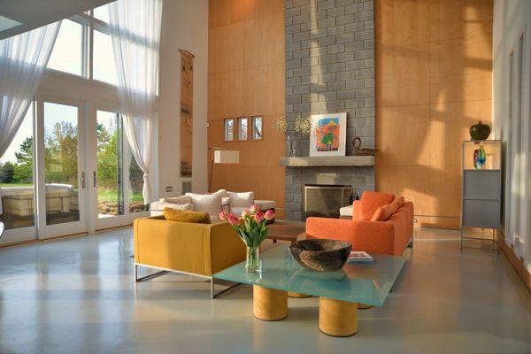 The living room area at Prairie Wind with 30 foot ceilings facing the Chesapeake Bay and the sun setting over the water