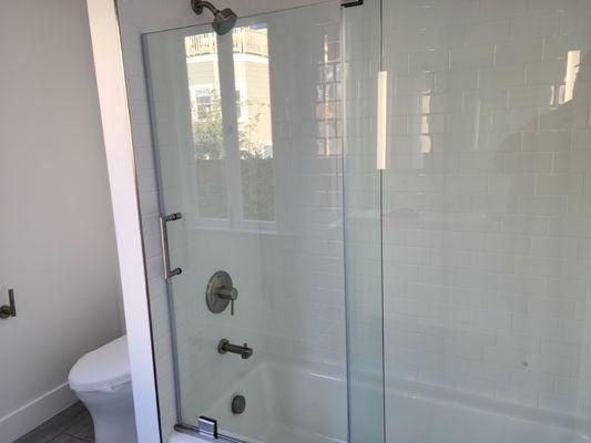 Frame less shower door, new faucet fixtures with subway pattern tile.