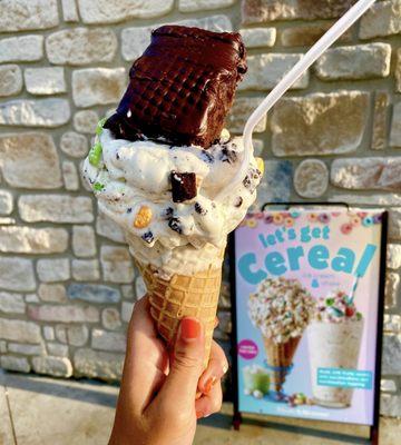 Regular size cereal ice cream mixed w/ cereal & brownie, topped w/ a brownie from Great American Cookies in white choc waffle cone