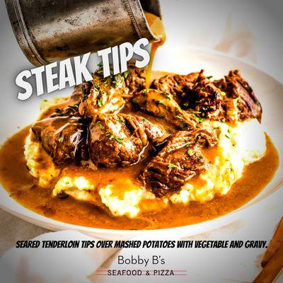 Seared tenderloin tips over mashed potatoes with vegetable and gravy.