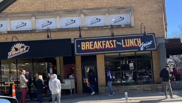 Front door showing people waiting outside for a table