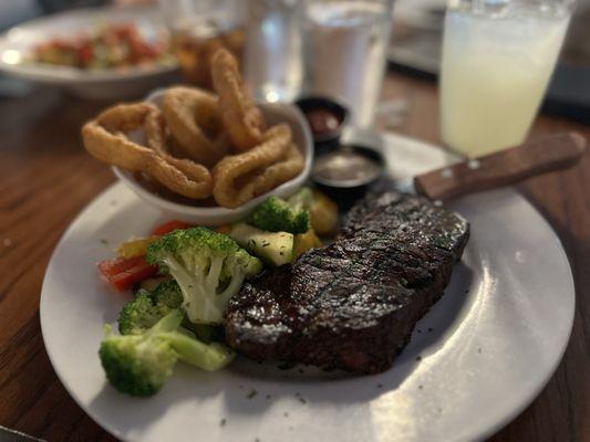 New York Strip with onion rings and steamed veggie mix.