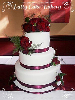 Three tiered wedding cake with roses.