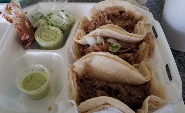 Two carnita and one barbacoa(couldnt wait and ate one before i got a picture) green sauces onions n cilantro and red sauce in bag.