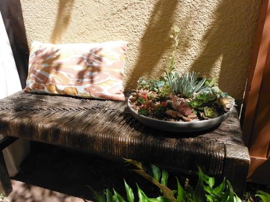 Even Small gardens can be organized to have "rooms" or special places to relax like this bench adorned with a bowl of succulents