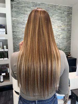 Invisible tape in  hair extendions. Golden brown hair color with beige highlights.