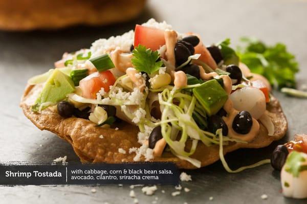 Shrimp Tostada with cabbage, corn & black bean salsa, avocado, cilantro, sriracha crema