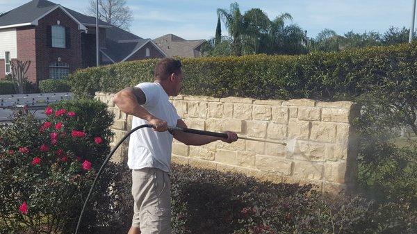 Pressure washing an HOA monument.