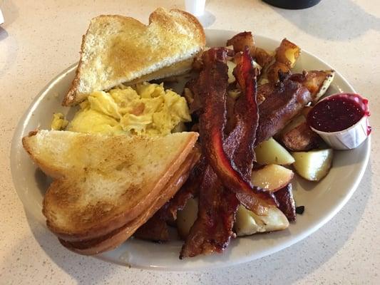 Scrambled eggs, bacon, redskin potatoes, homemade toast with strawberry jam