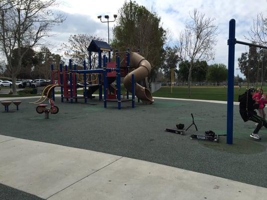 Bigger kids' playground next to pool, basketball, courts, and parking lot