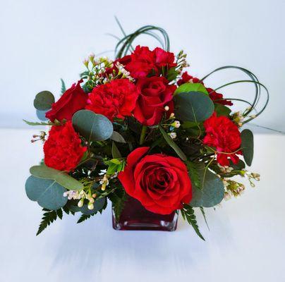 Red roses with red carnations in a cube vase