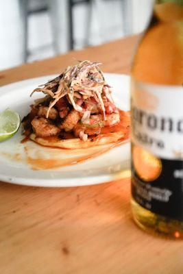 Delicious shrimp taco behind a fresh bottle of Corona Extra