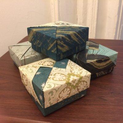 Origami boxes in a collection of teal and natural papers.