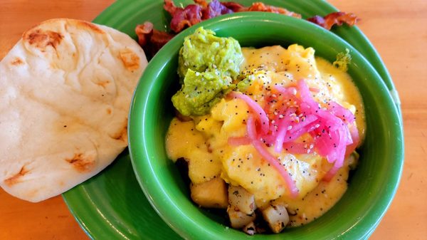 Smashed avocado bowl with a side of bacon.