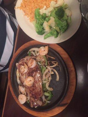 Shrimp and steak with a side of rice and veggies