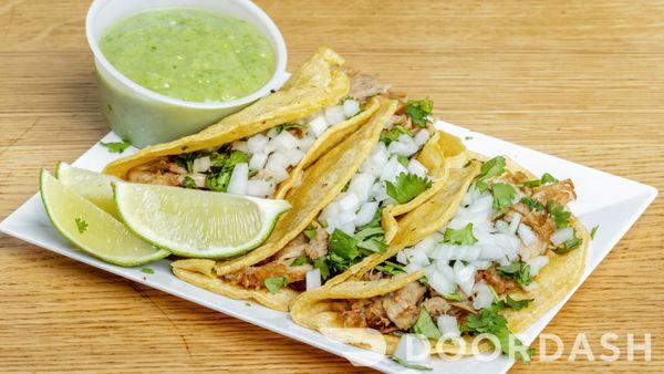 Authentic Mexican Tacos- Soft Corn Tortillas with Carnitas, Onion, and Cilantro. Served with Fresh Limes, Red and Green Salsa.