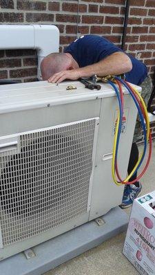 John giving the Mitsubishi ductless outside unit a tune up and cleaning.