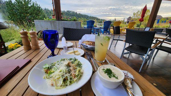 Caesar salad, cup of clam chowder and pear non-alcoholic drink on patio