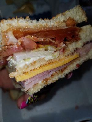 Mayberry Club Sandwich w/ham - close up. Comes with white bread toasted, bacon, ham, lettuce, tomato, American cheese, mayo