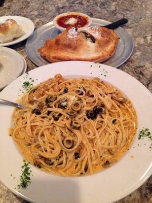 Blackened chicken over linguini. I substituted the artichokes for black olives. A delicious calzone is in the background.