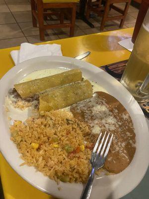 Shredded beef enchiladas with cheese sauce, rice and beans.