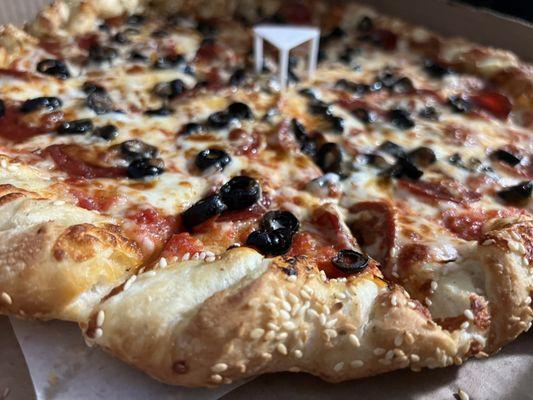 Pepperoni and black olive on sesame crust, soft delicious dough and pizza.