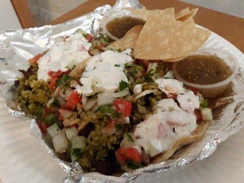 Three steak tacos with cilantro rice,sour cream, roasted corn salsa on flour tortillas