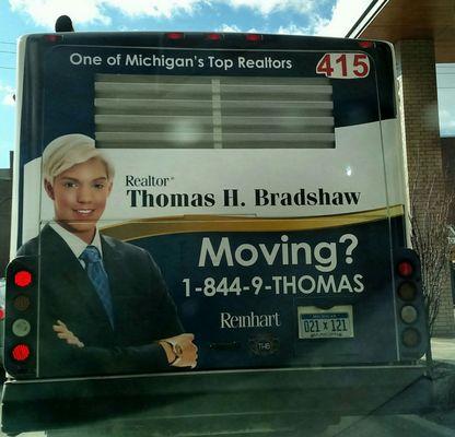 Bus ad for Reinhart Realtors: A dude who looks like a lady or woman in man's suit? Curious minds want to know!