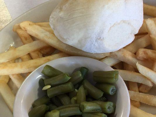 This is a bowl with canned green beans, frozen French fries, and a standard grocery dinner roll.  This accompanied the steak