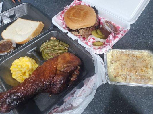 Everything you want in one photo - brisket sandwich,  turkey leg with sides and banana pudding