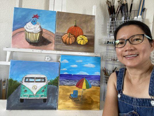 Local artist Esperanza Deese with paintings she personally created for the Paint & Sip classes