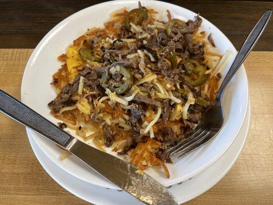 Sausage, cheese, over easy egg, hash brown bowl with jalapeños.