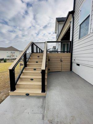 Composite decking with cable railing, black aluminum gate and composite deck skirting for storage