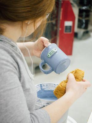 Glazing mugs by hand in our pottery studio.