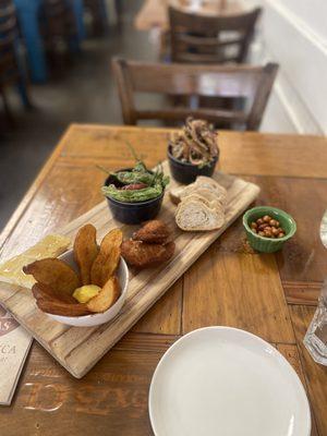 5-item plate: peri-peri potatoes, dungeoness crab empadas, chouriço and shishito peppers, fried pigs feet, and a cheese with honey.