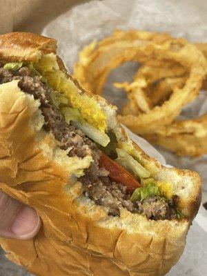 Thin beef patty from the griddle on a toasted bun with all the fixings.