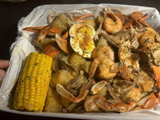 Crab, shrimp, potatoes, egg, and corn