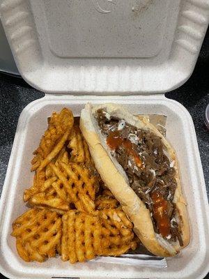 cheesesteak with hot sauce and waffle fries