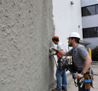 Our team pplying stucco on a large commercial building exterior.