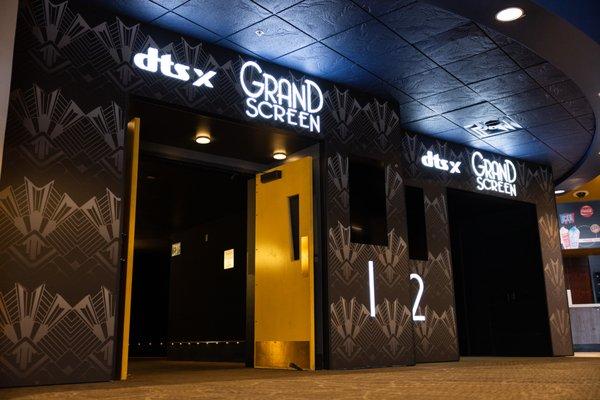 Entrance to 2 Grand Screen auditoriums featuring illuminated Grand Screen with DTS:X signs