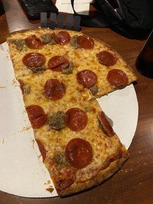 Half eaten sausage and pepperoni pizza