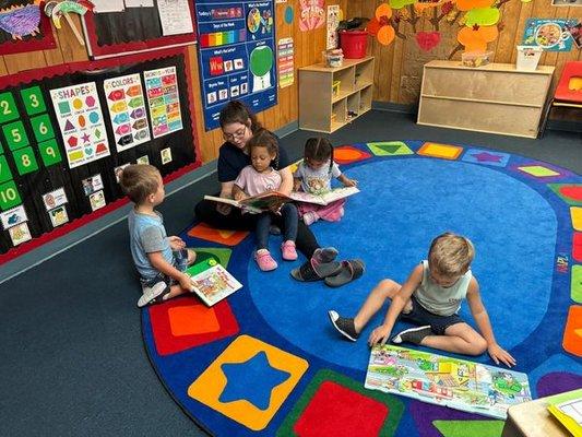 Preschoolers enjoying story time, after choosing their favorite book from the Reading Center