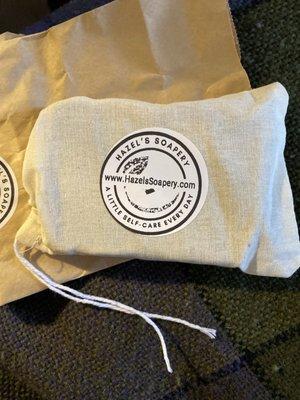 A bar of handmade soap with essential oils still in the little fabric travel bag