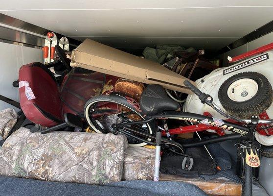 70lb tow behind sprayer with metal frame stacked on top of collectible bike ( never ridden) and against trailer wall