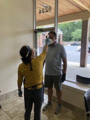 Body temperature check before haircut. Safety first!