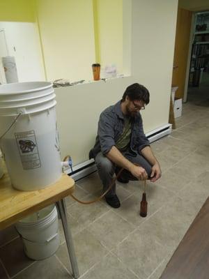 Using a siphon to fill the beer bottle