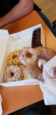 Vanilla sprinkle, chocolate eclair, glazed blueberry, and cruller donuts.