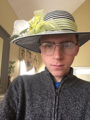 A derby hat along with a grey sweater